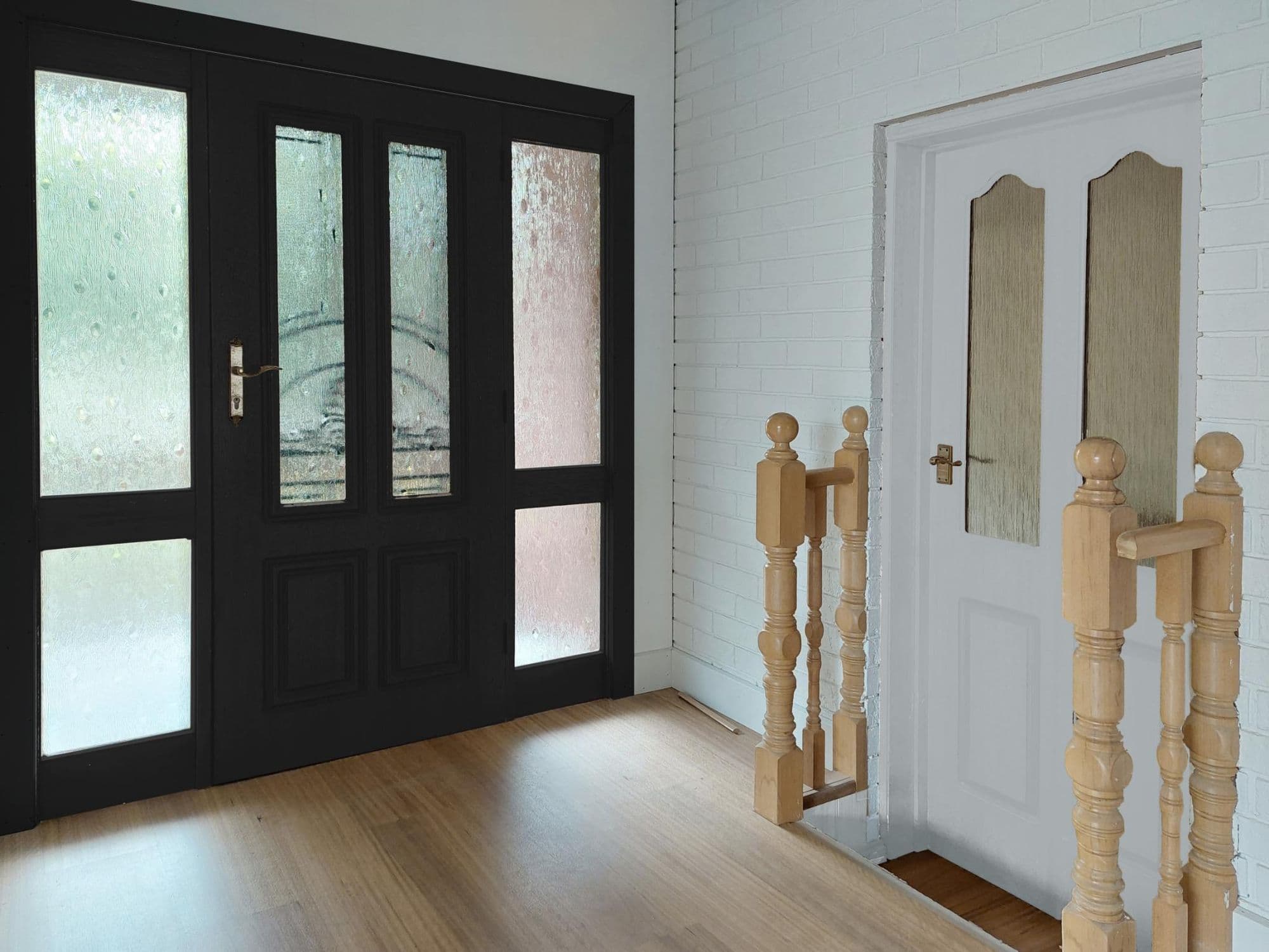 Matte-black glazed double entry doors with warm timber flooring — Tricoat finish