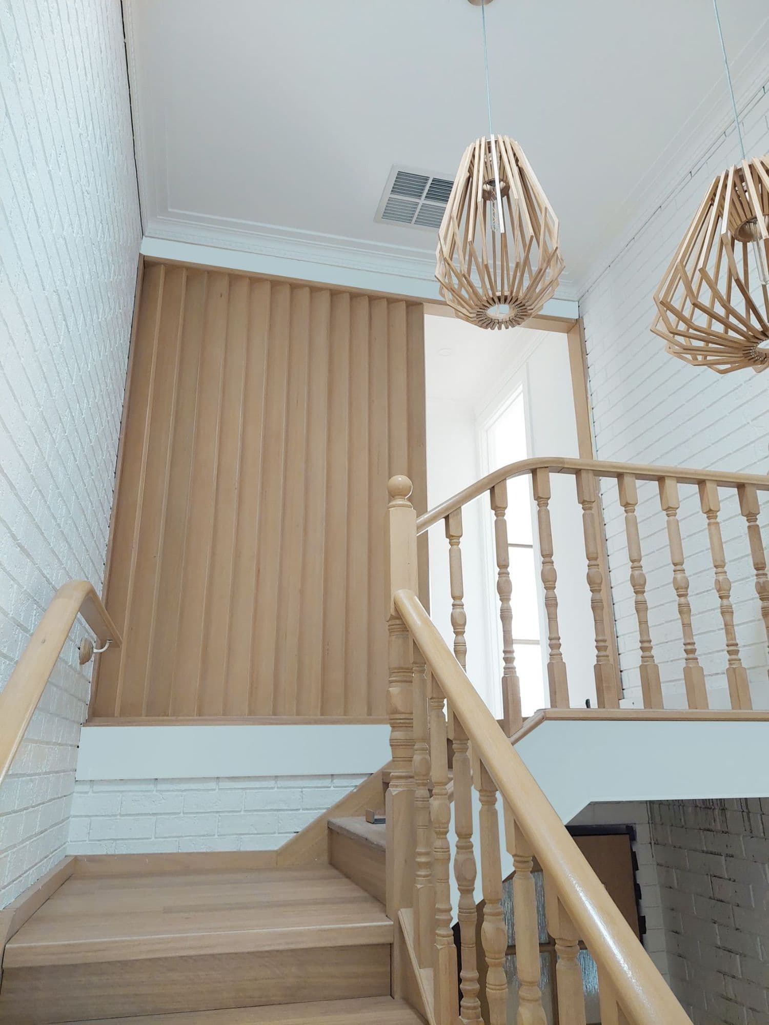 Timber-battened feature wall with twin pendant lights over a staircase — finished Tricoat interior