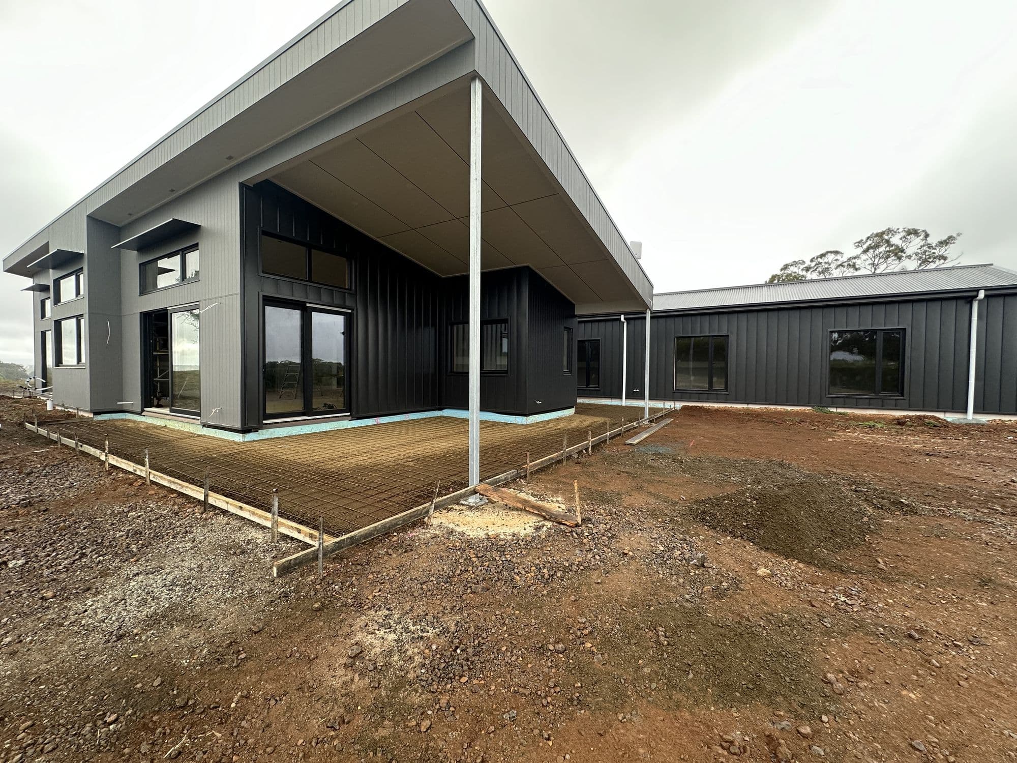 Angled view of a charcoal-clad new home exterior painted by Tricoat